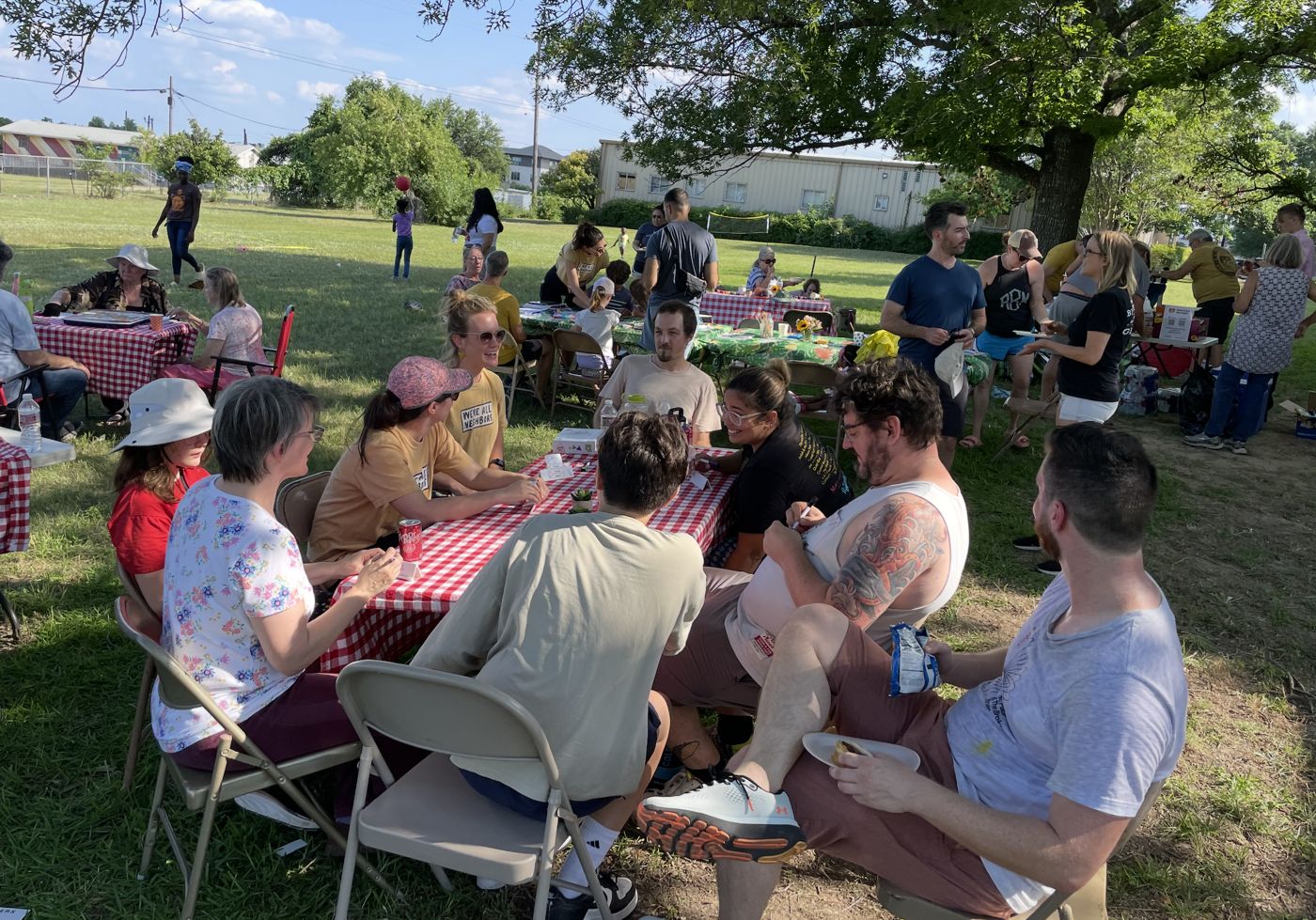 Neighbors at checkered picnic tables in a park